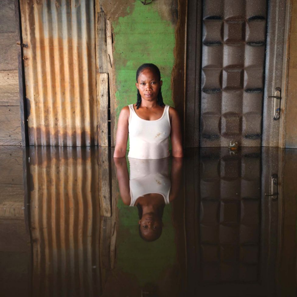 Janet Eke standing in flood water at her home in Ogbia Municipality, Bayelsa State, Nigeria - November 2022