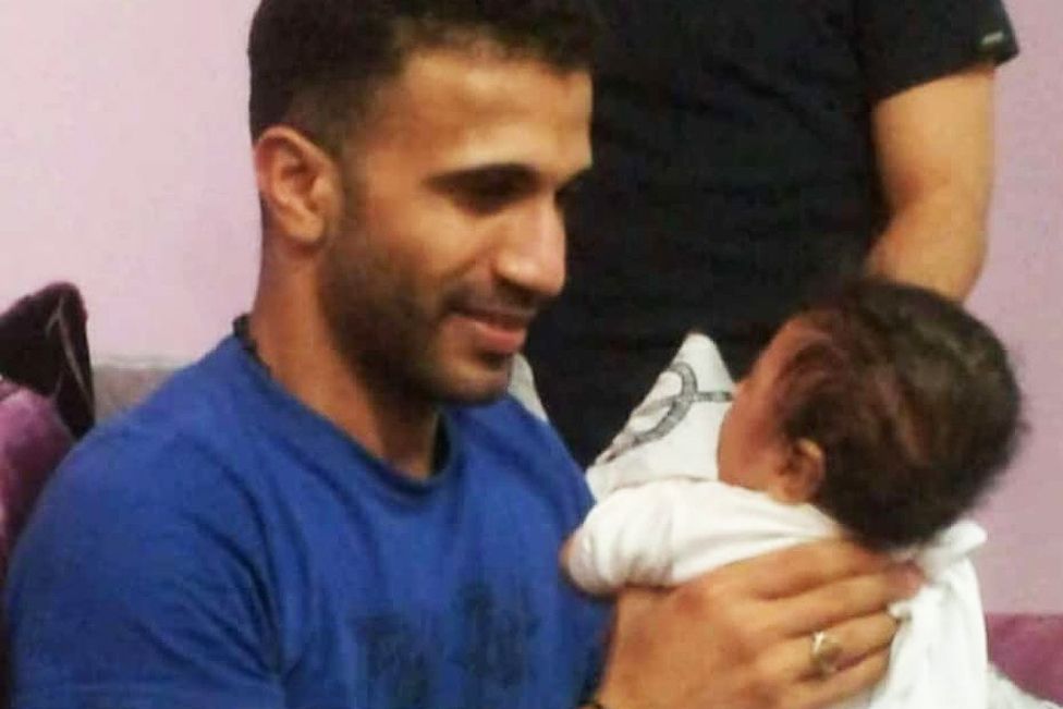 Mustafa al-Khayyat, one of 81 men executed on a single day, holding his baby nephew