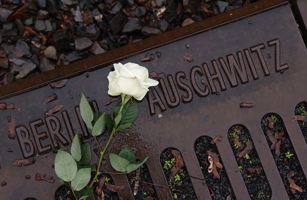 A flower lies at the railway tracks at the Gleis 17 memorial on Holocaust Remembrance Day on 27 January 2023 in Berlin, Germany