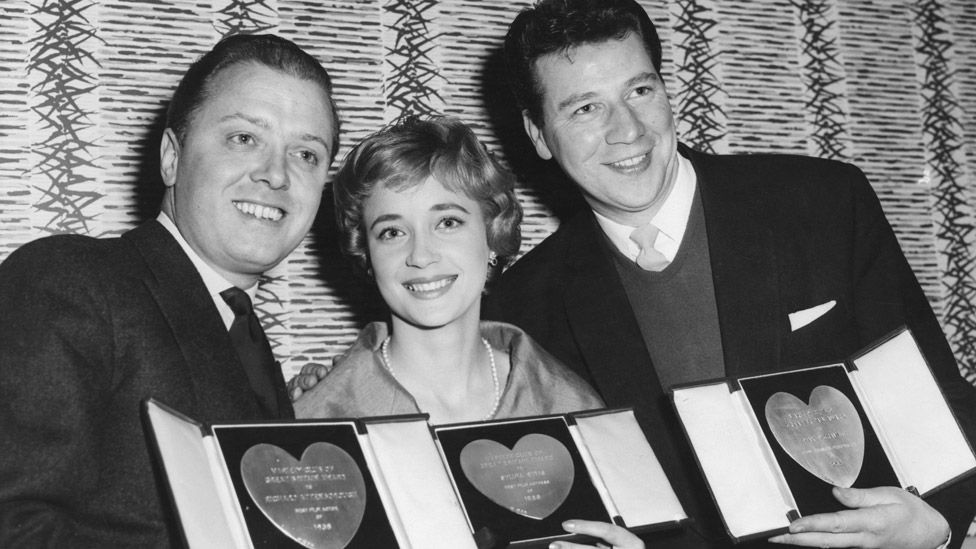 Left-right: Richard Attenborough, Sylvia Syms and Max Bygraves with their awards at the Variety Club Annual Show Business Awards Luncheon at the Savoy Hotel in London, 10th March 1959