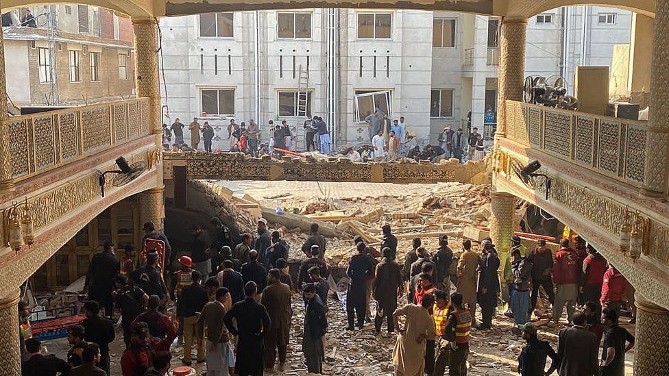 Security officials inspect the site of a mosque blast inside the police headquarters in Peshawar on January 30, 2023.