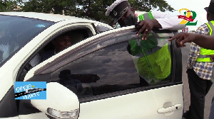 Police and DVLA officials remove the tint from the from windows of a car during compliance checks
