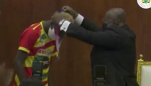 President Nana Akufo-Addo putting the medal on Samuel Takyi