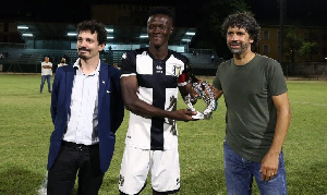 Ahmed Awua (middle) receives his award from an official