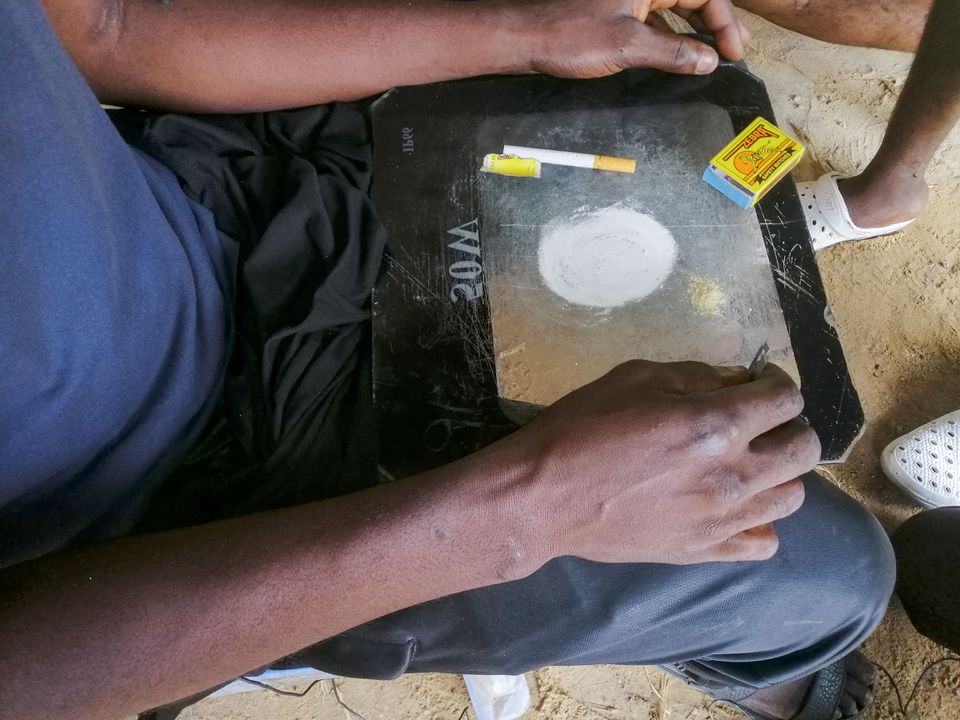 A man shows a substance known as "bombe", a mix of catalytic converters' crushed honeycomb and pills, before snorting it, in Kinshasa, Democratic Republic of the Congo August 31, 2021. Picture taken August 31, 2021. REUTERS/Benoit Nyemba