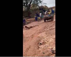 The suspected criminal tied to the tricycle and being dragged on the muddy road