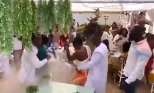 A picture of the groom dancing with his guest whiles his friends cheer him up