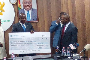 Minister for Lands and Natural Resources, Samuel A. Jinapor with the cheque