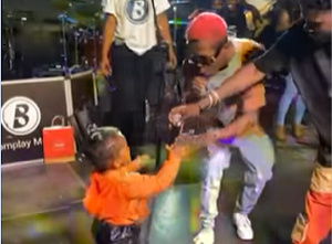 Strongman captured on stage with his daughter and Kuami Eugene