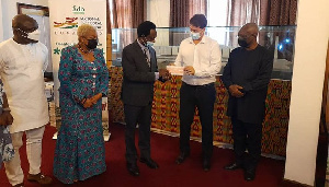 The investor (second right) presents a cheque to Prof Apostle Onyinah