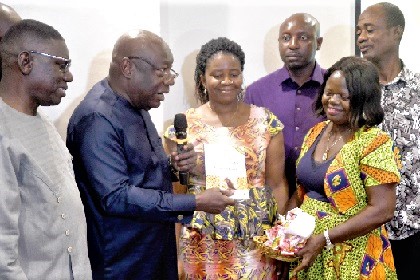 Dr Kwaku Afriyie (2nd from left), Minister of Environment, Science, Technology and Innovation, displaying the National Policy document on aflatoxins at the launch in Accra
