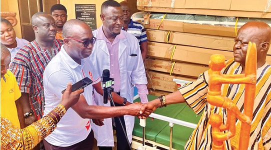 Robert Kyere (left) presenting the beds to Osabarima Ofosuhene Apenteng II, Asuomhene, while Maxwell Atuanor Dwirah and Kwasi Ansah Antwi Boasiako, the Asuom Health Centre Medical Assistant, look on