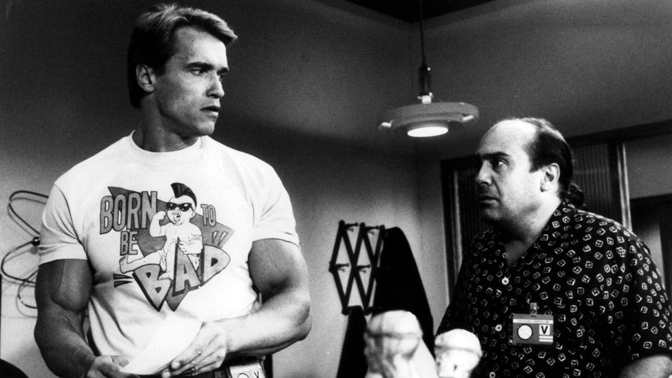 Arnold Schwarzenegger looking back at Danny DeVito in a scene from the film 'Twins', 1988.