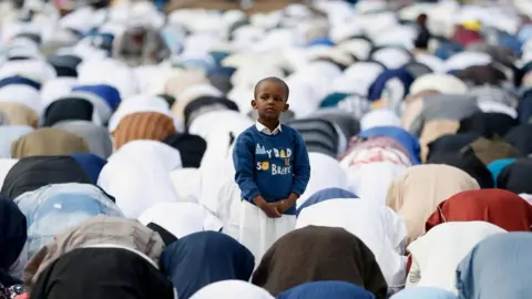 Reuters A boy standing ds in the middle of a crowd of people praying in the prostration position in Nairobi, Kenya.
