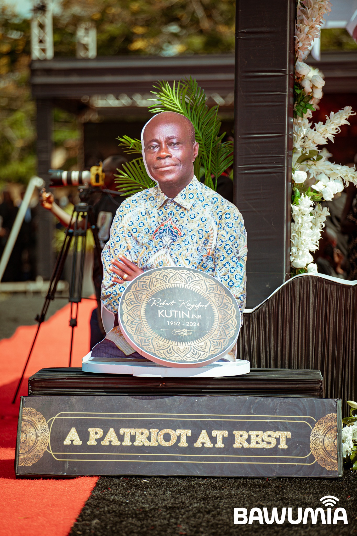 May be an image of 2 people, dais and text that says 'Rubert RobutKifu Kagiut KUTIN KUTINJNR NR 1952 2024 Oralm PATRIOT AT REST BAWOM UMĨA BAWU'